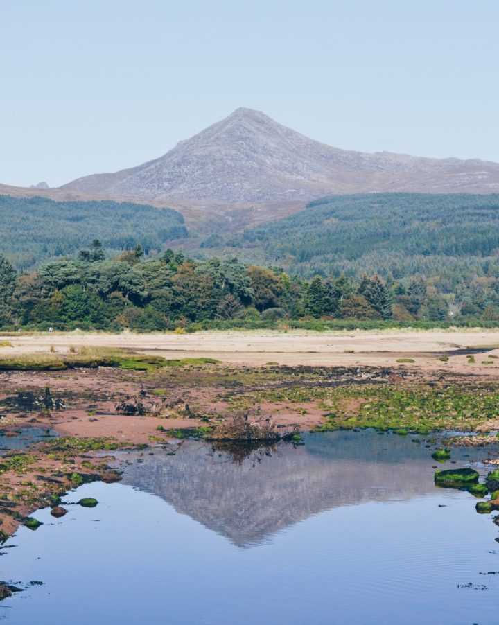 The mountain of Goatfell reflected in water along the Fisherman's Walk, Brodick